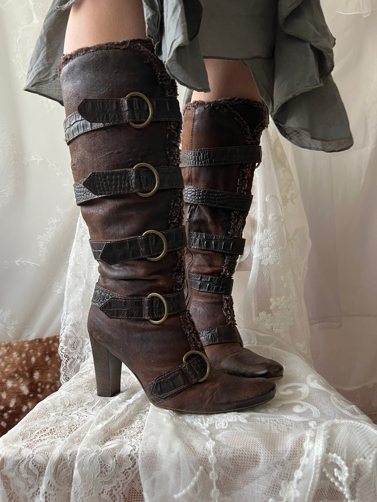 Brown leather knee high boots with buckles and faux fur trim
