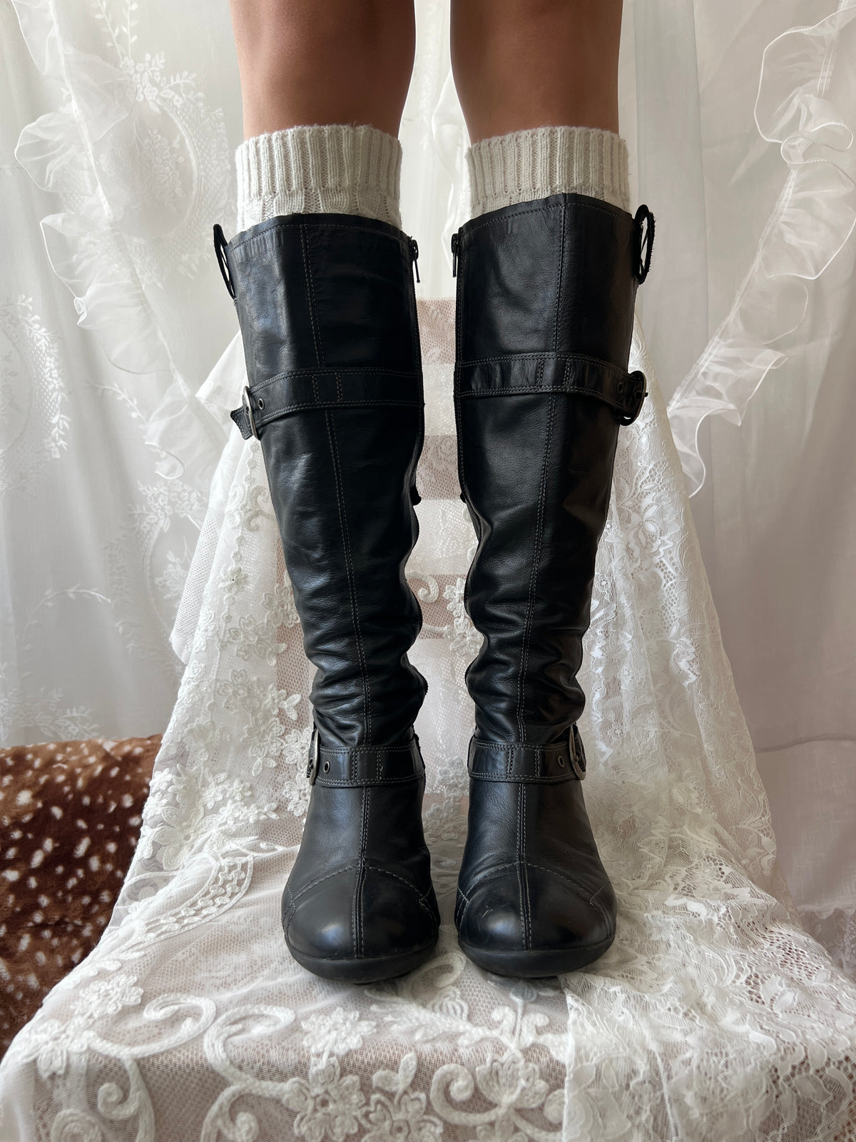 Black knee high boots with silver buckles