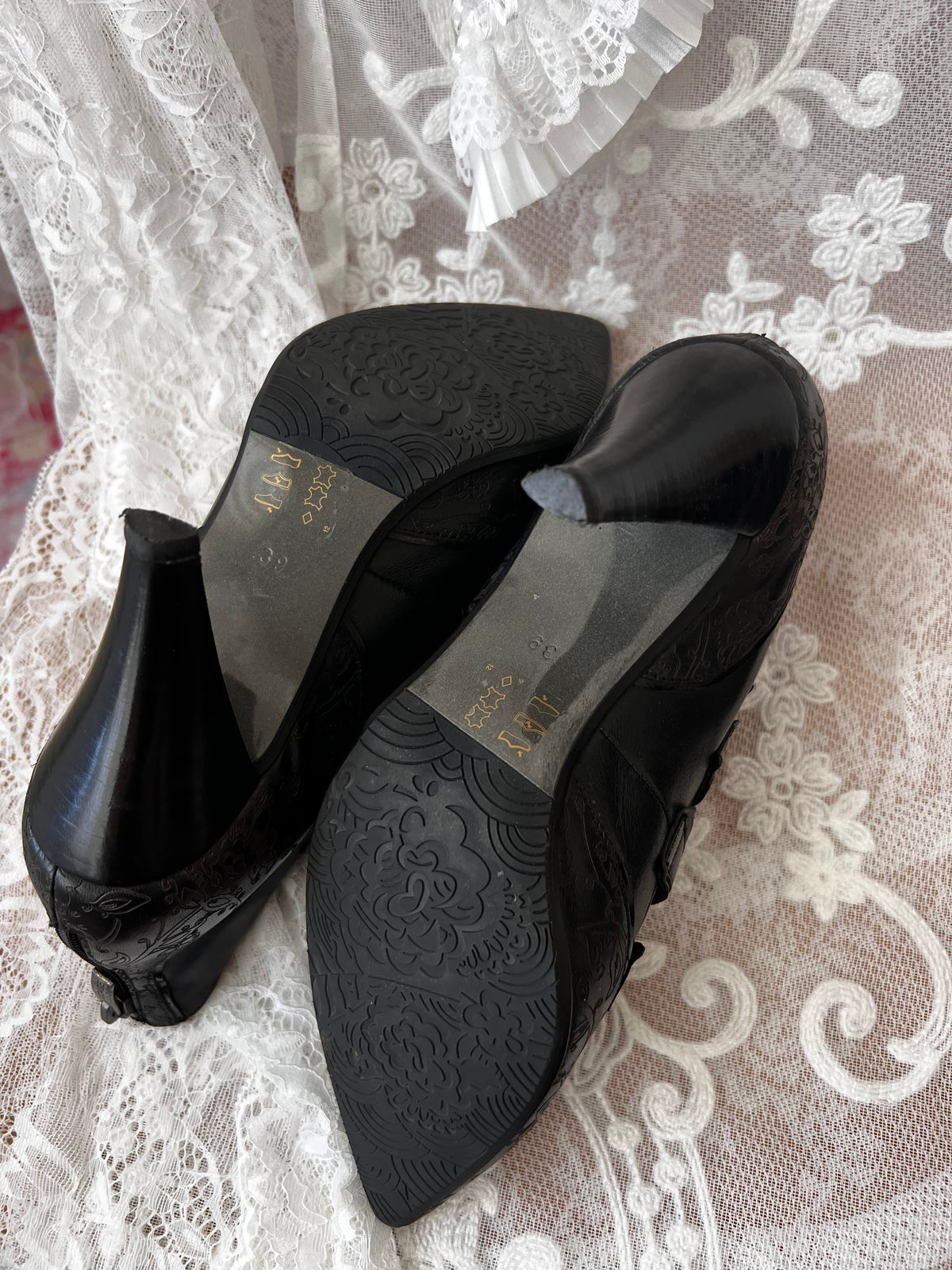 Black leather kitten heels with pointed toe and button details