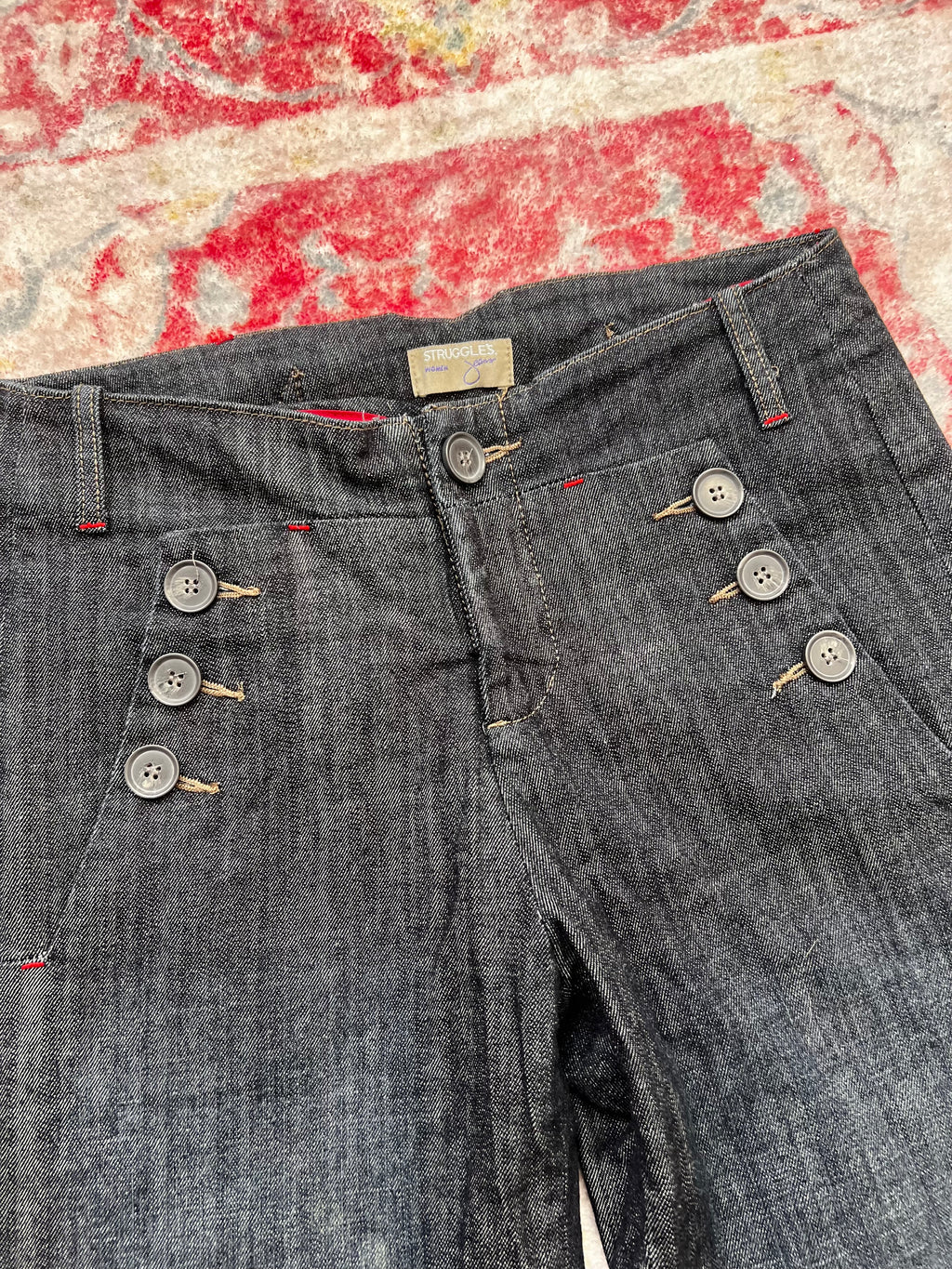 Dark wash denim jeans with button details and wide leg fit