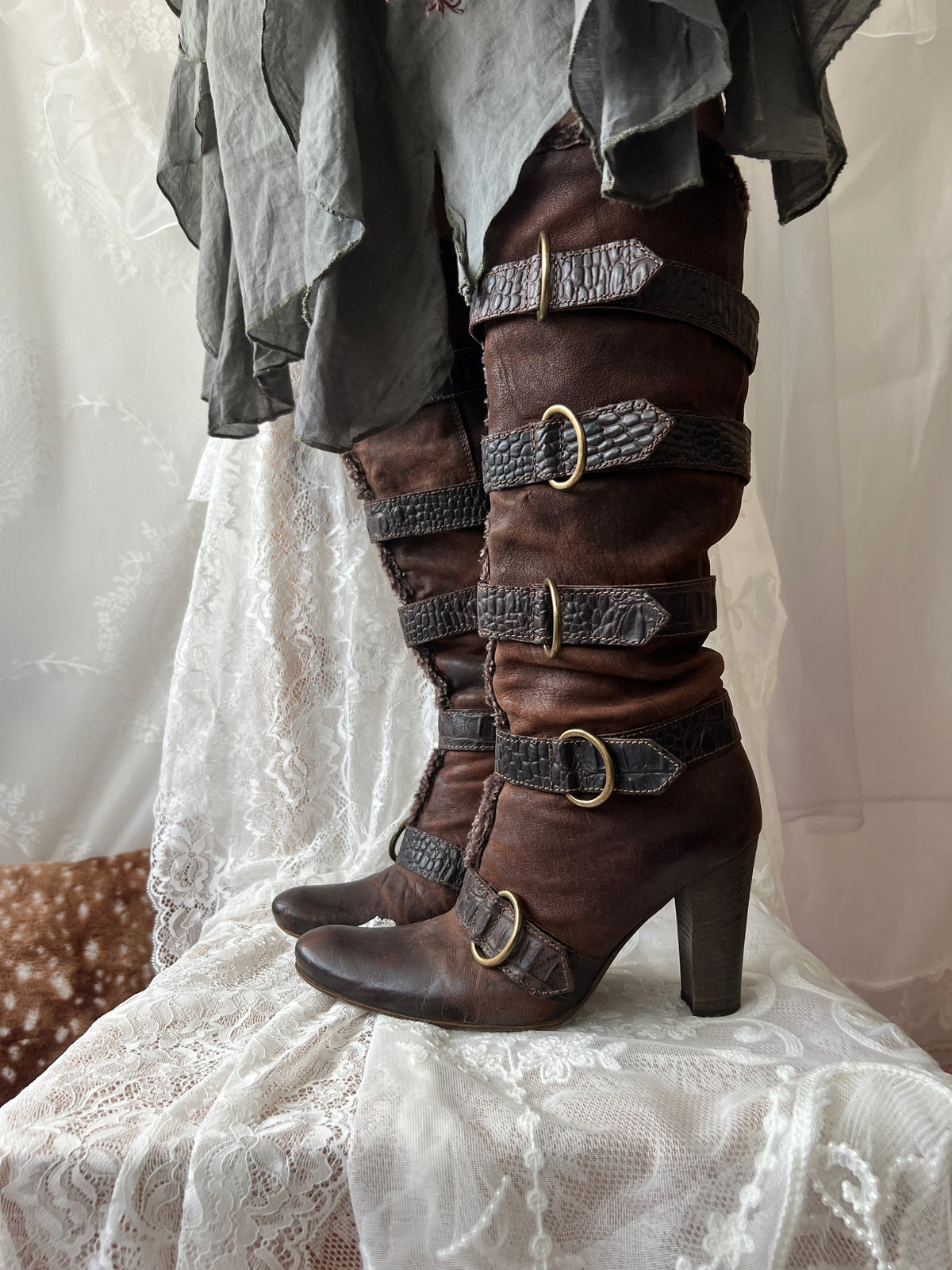 Brown leather knee high boots with buckles and faux fur trim