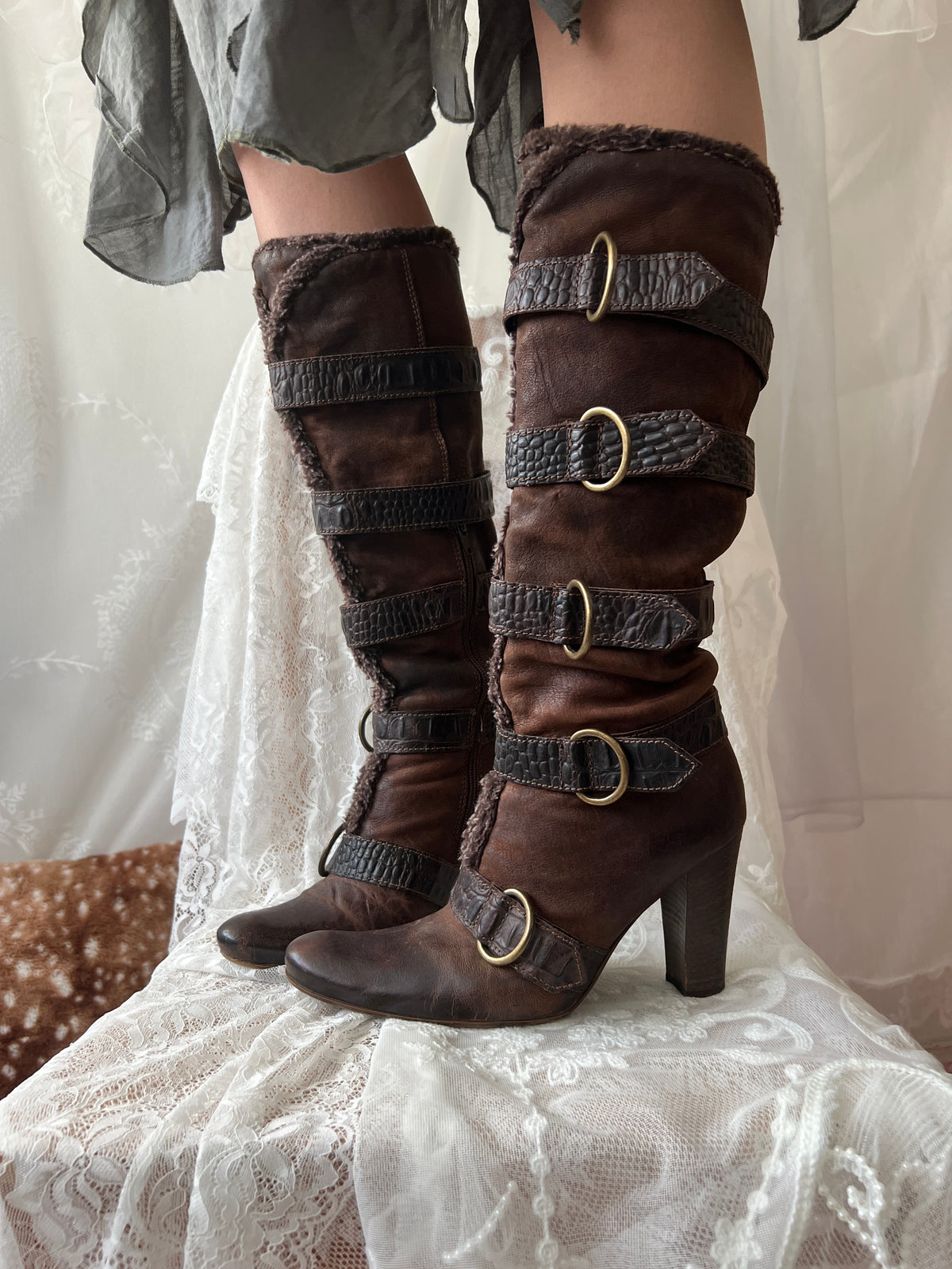 Brown leather knee high boots with buckles and faux fur trim