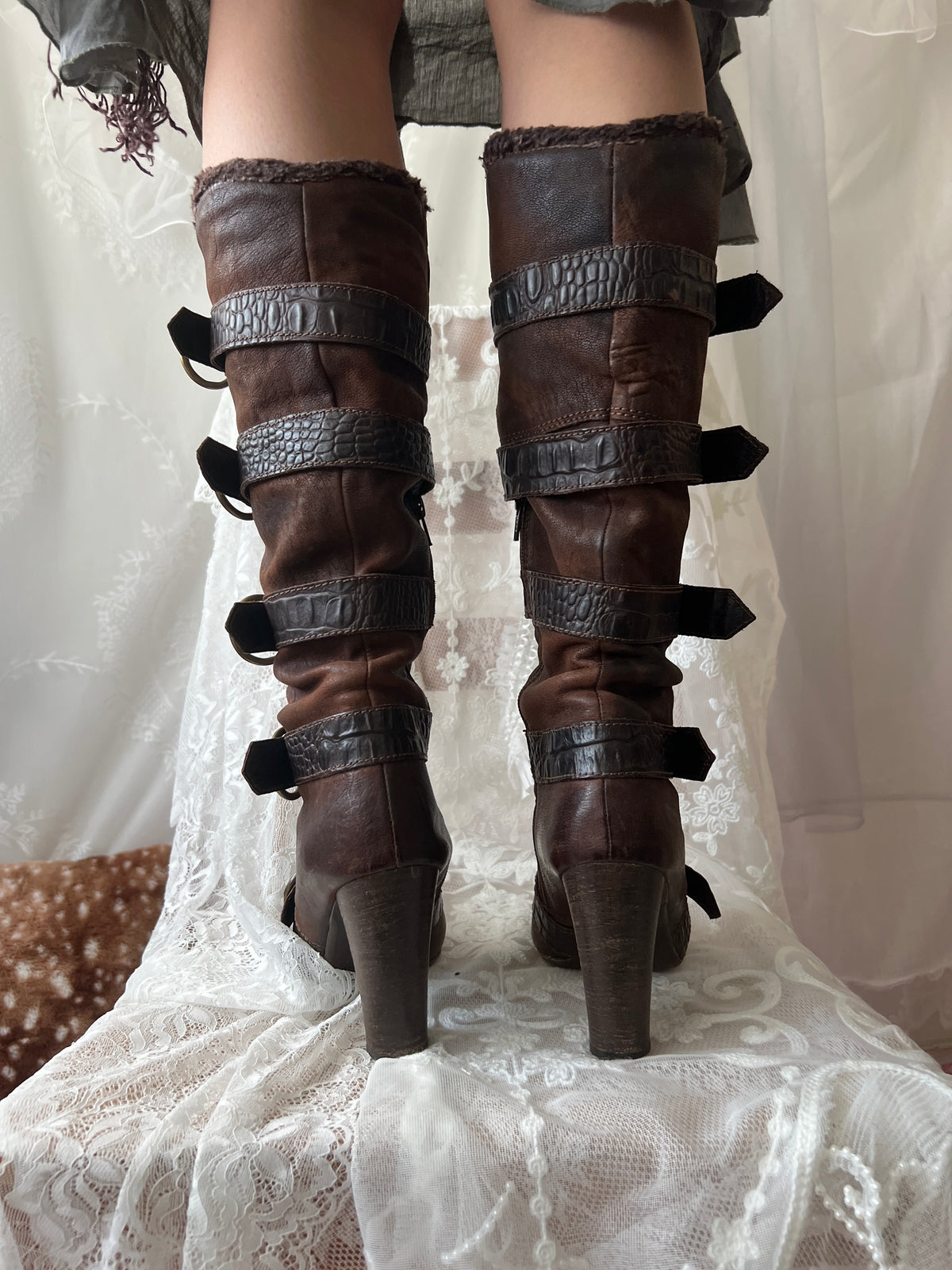 Brown leather knee high boots with buckles and faux fur trim