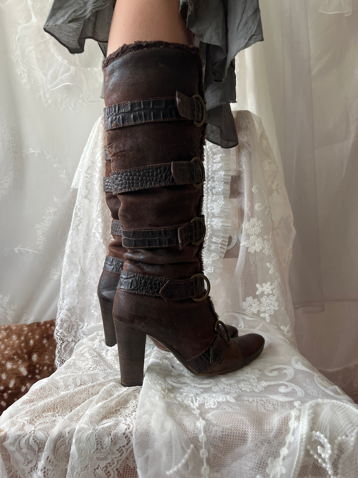 Brown leather knee high boots with buckles and faux fur trim