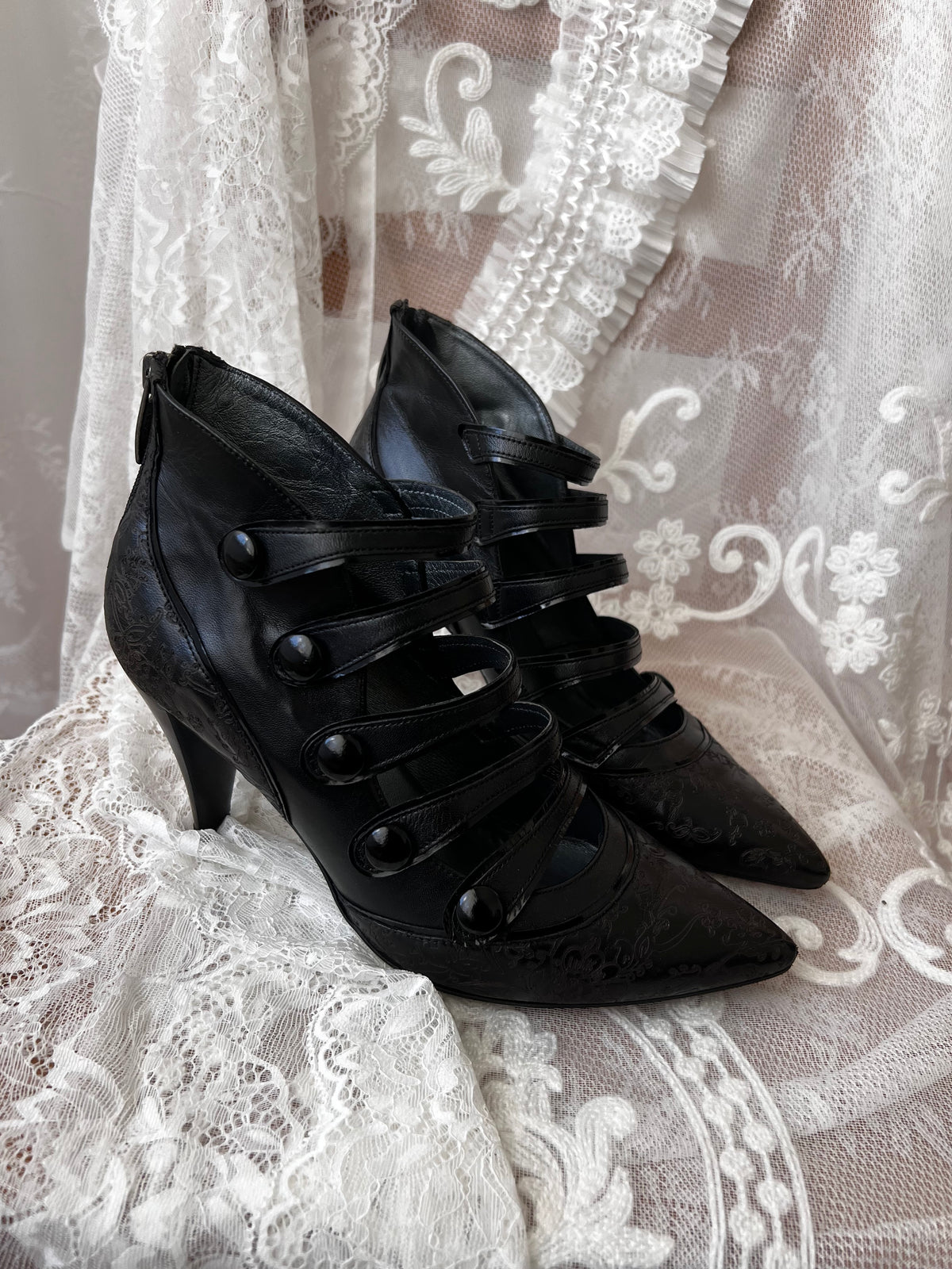 Black leather kitten heels with pointed toe and button details