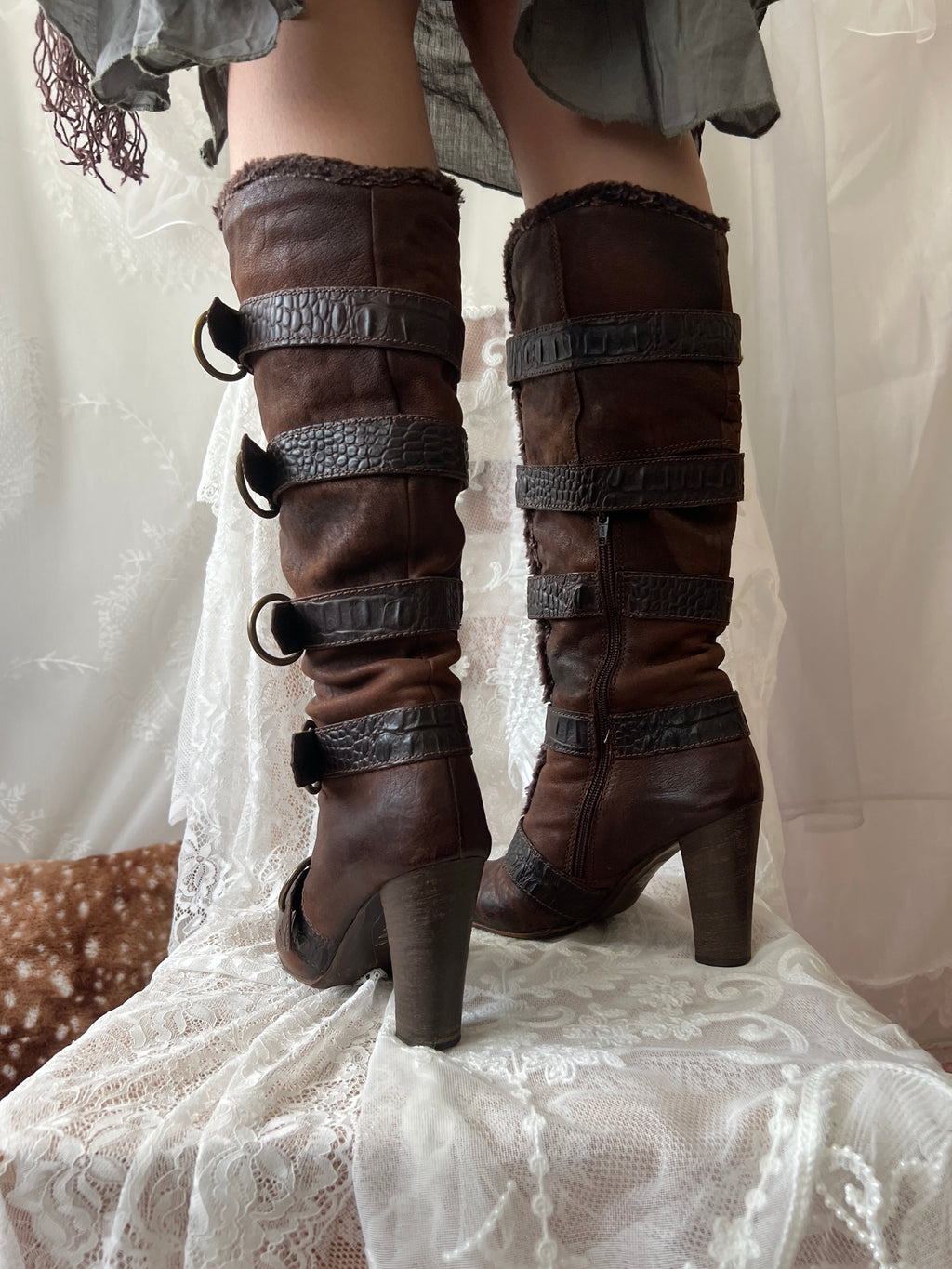 Brown leather knee high boots with buckles and faux fur trim