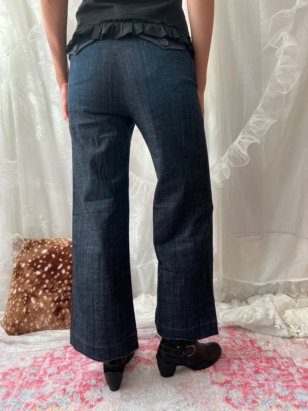 Dark wash denim jeans with button details and wide leg fit