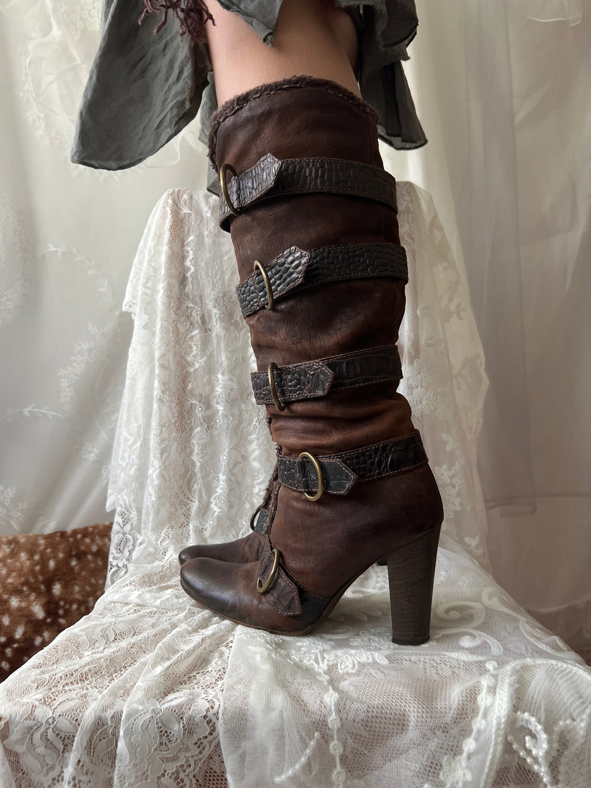 Brown leather knee high boots with buckles and faux fur trim