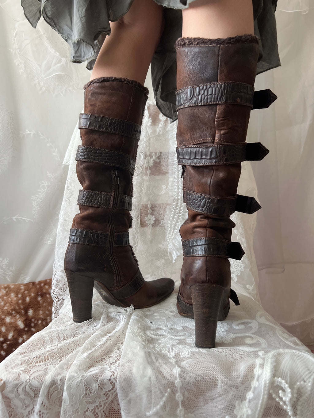 Brown leather knee high boots with buckles and faux fur trim
