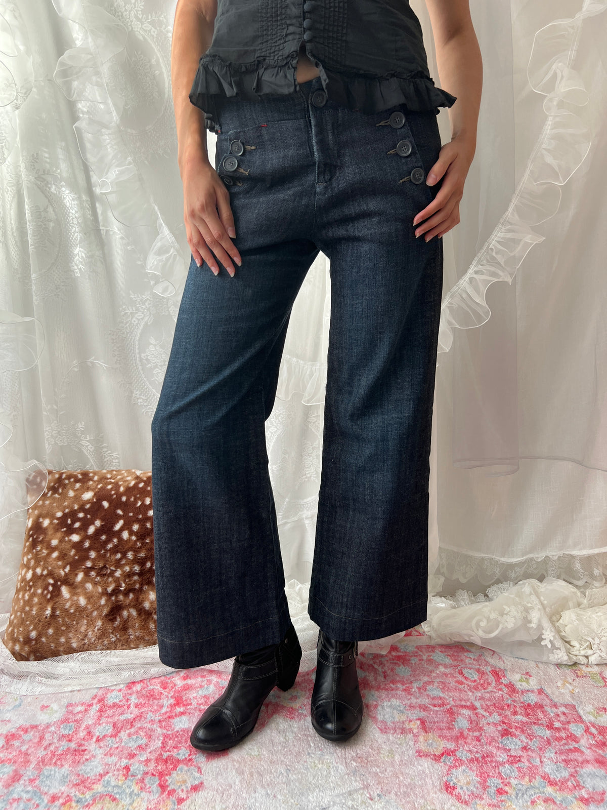 Dark wash denim jeans with button details and wide leg fit