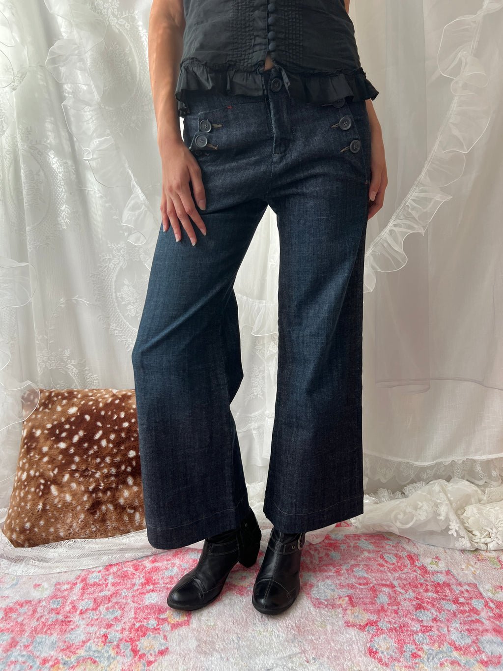 Dark wash denim jeans with button details and wide leg fit