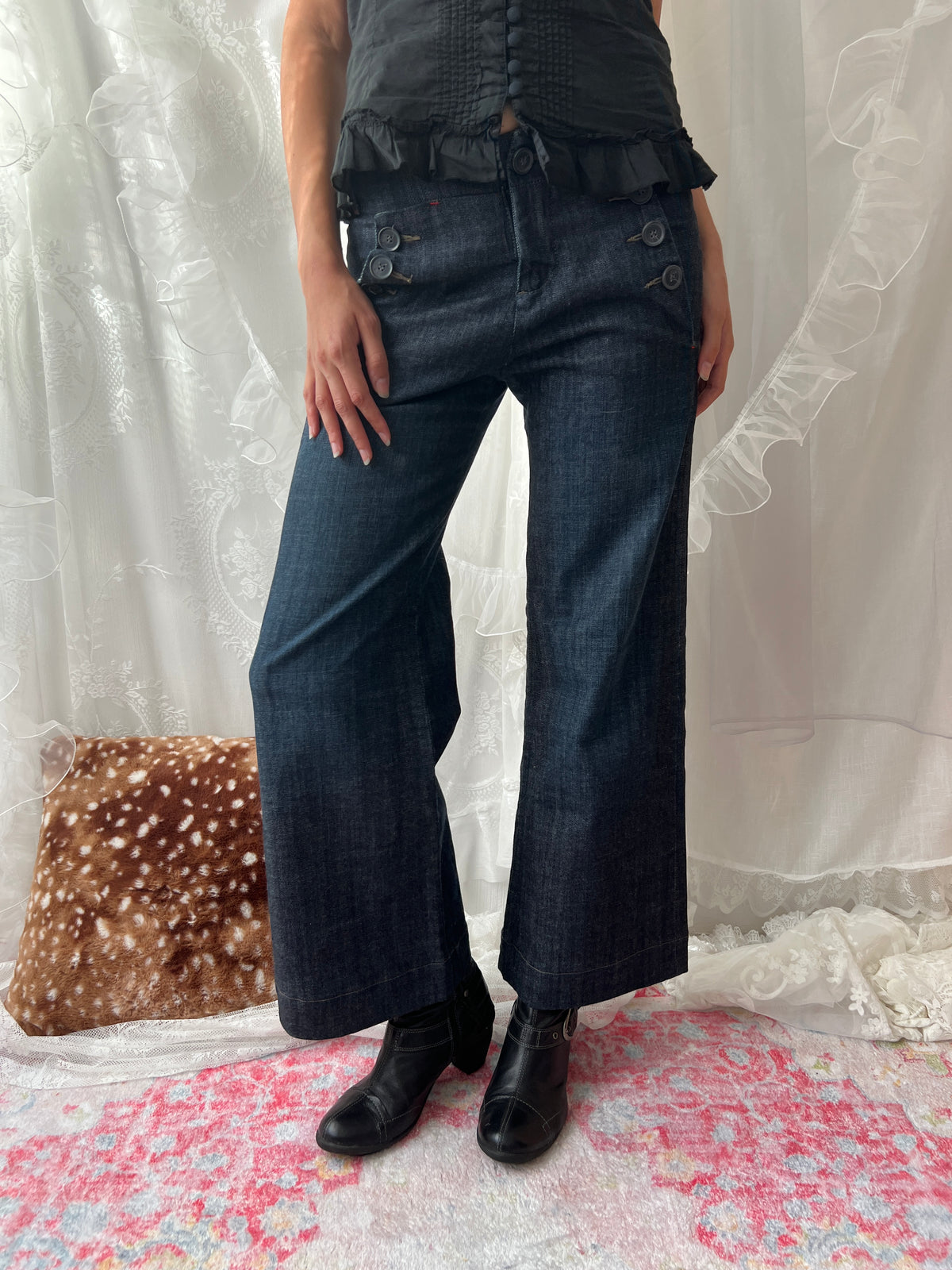 Dark wash denim jeans with button details and wide leg fit