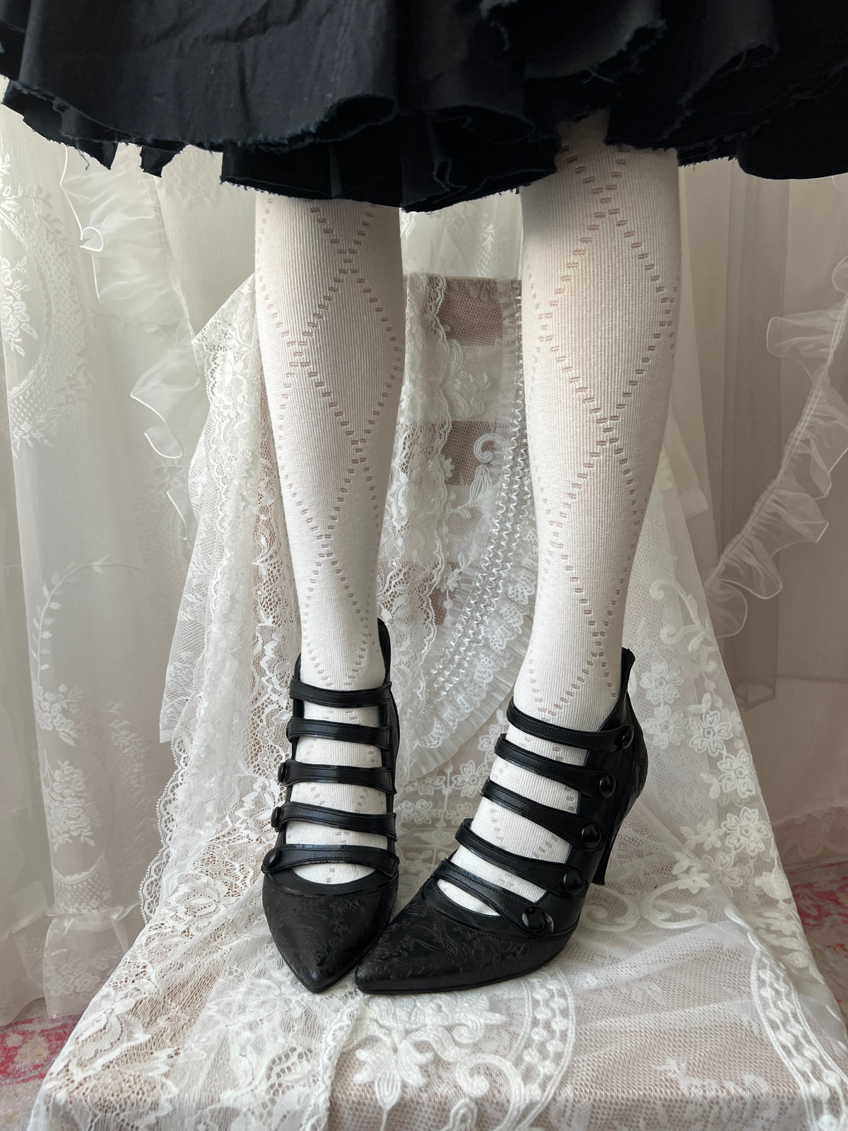 Black leather kitten heels with pointed toe and button details
