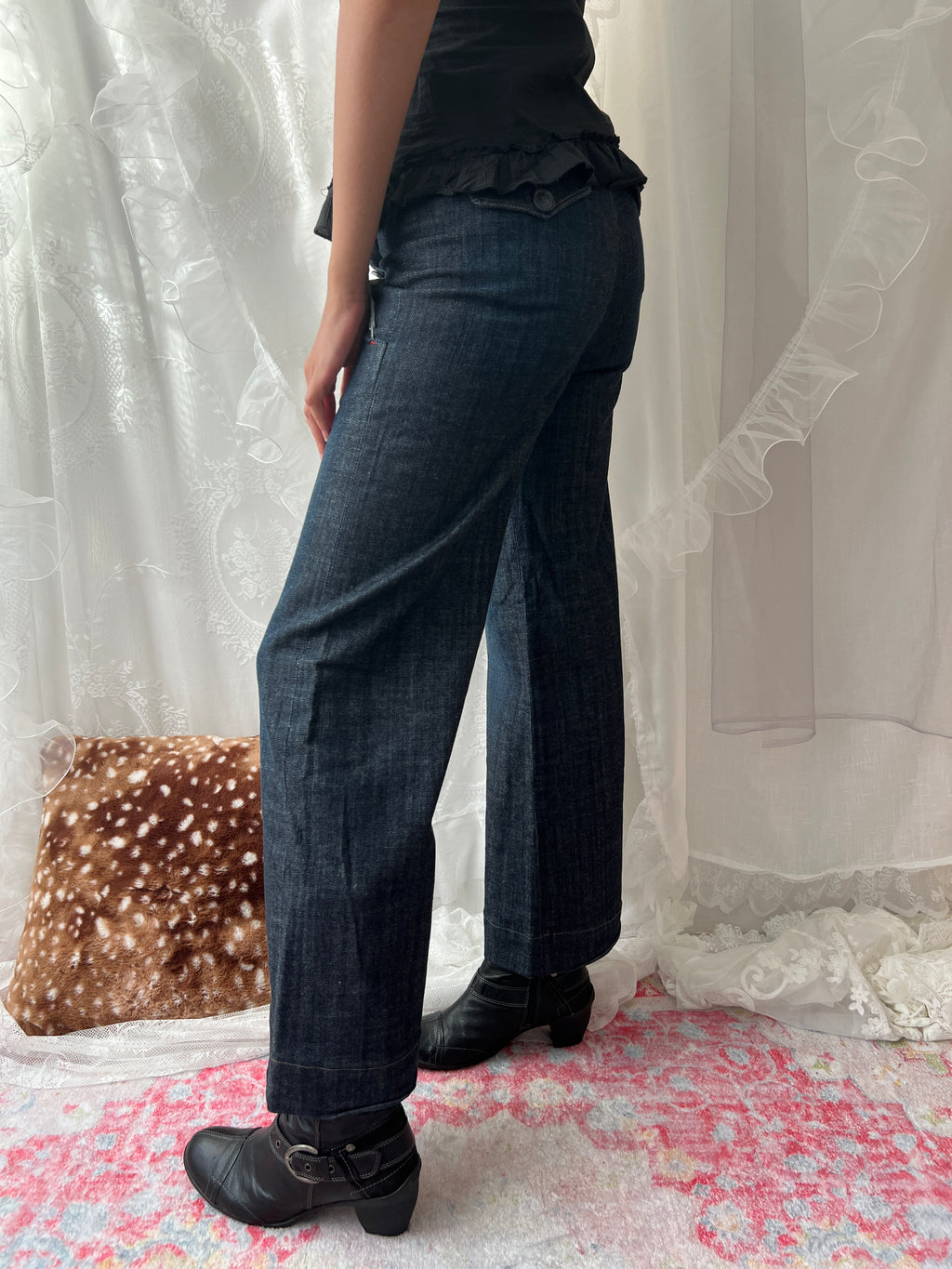 Dark wash denim jeans with button details and wide leg fit