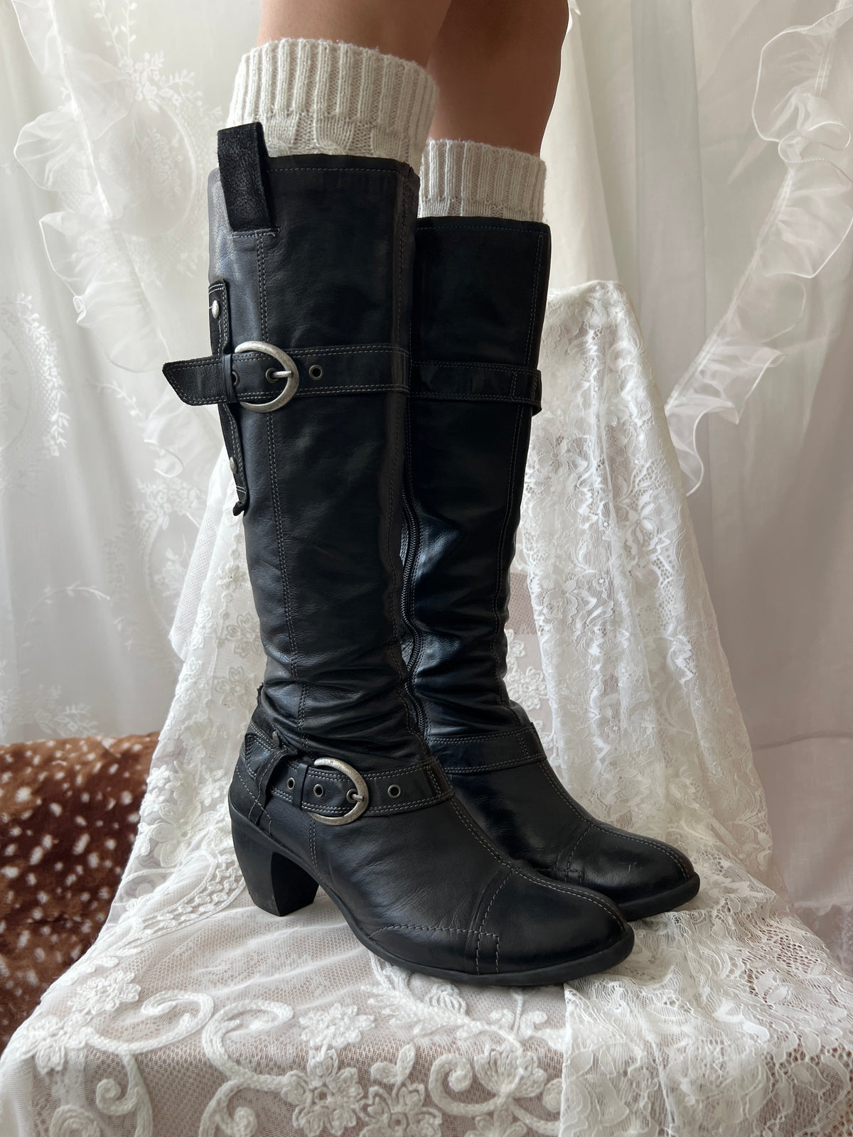 Black knee high boots with silver buckles