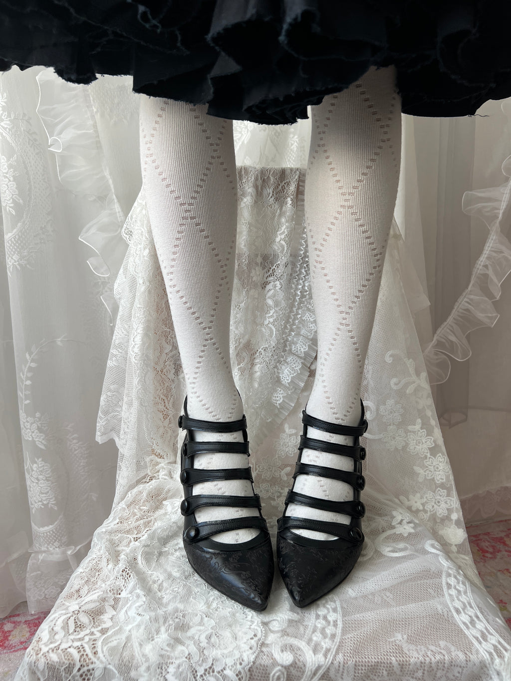 Black leather kitten heels with pointed toe and button details
