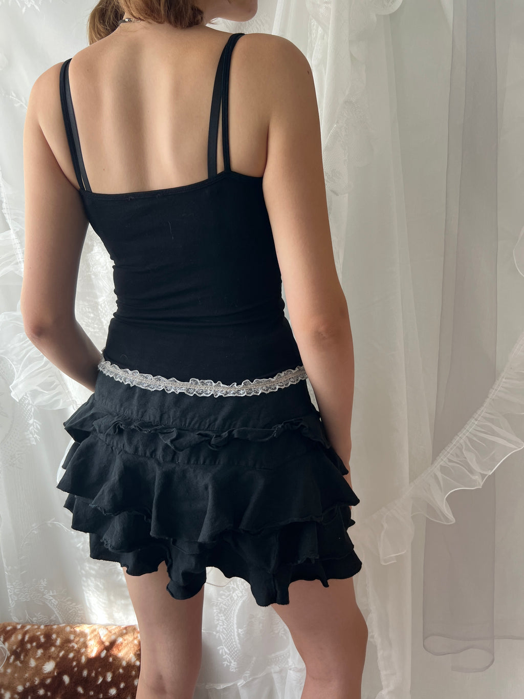 Black lace corset top with white lace trim and adjustable straps