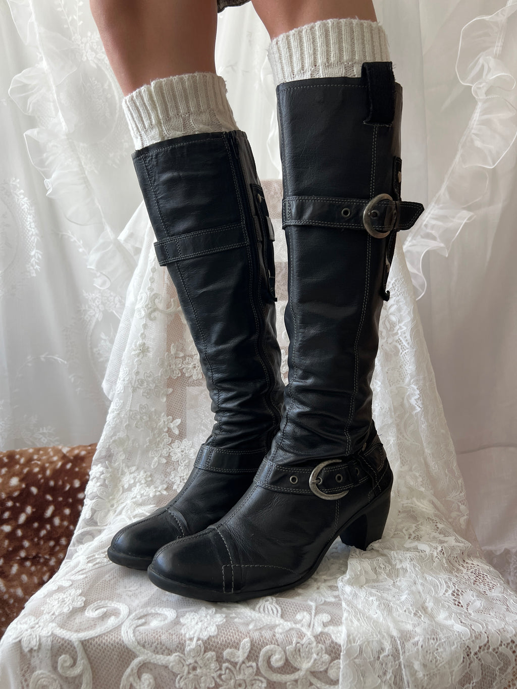 Black knee high boots with silver buckles