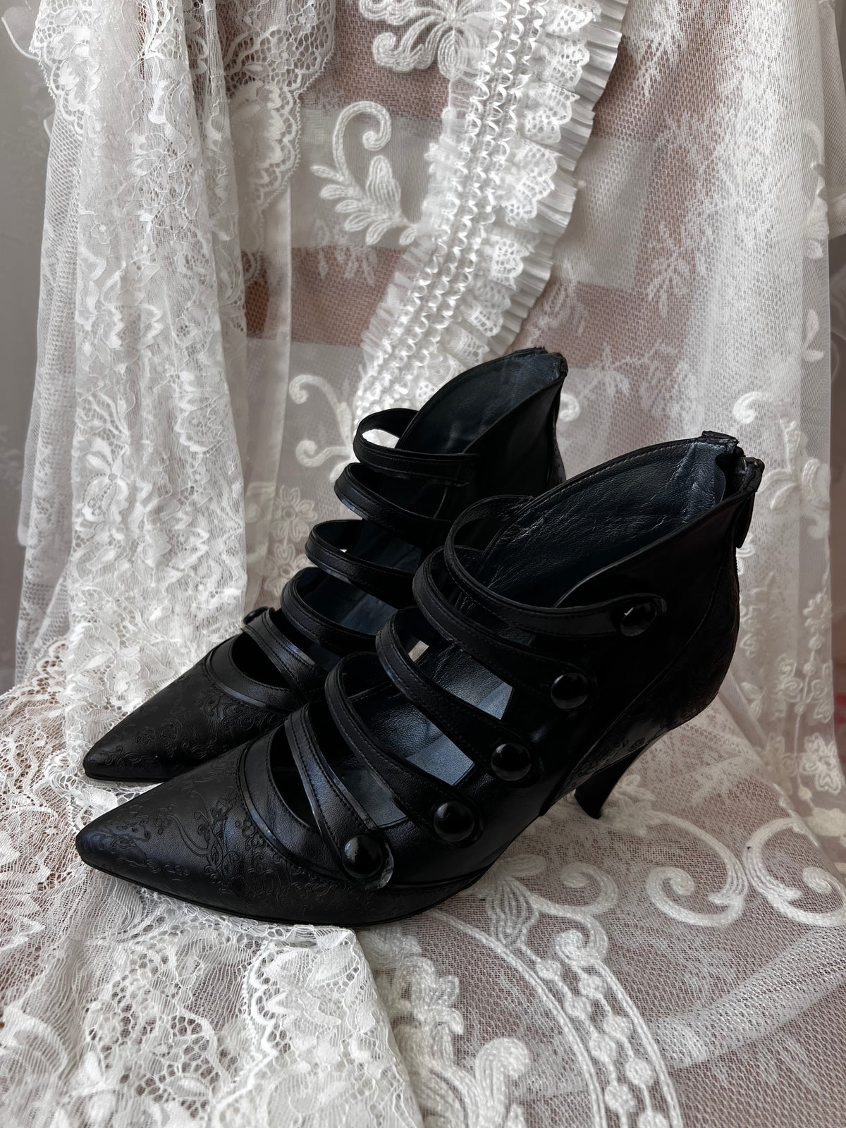 Black leather kitten heels with pointed toe and button details