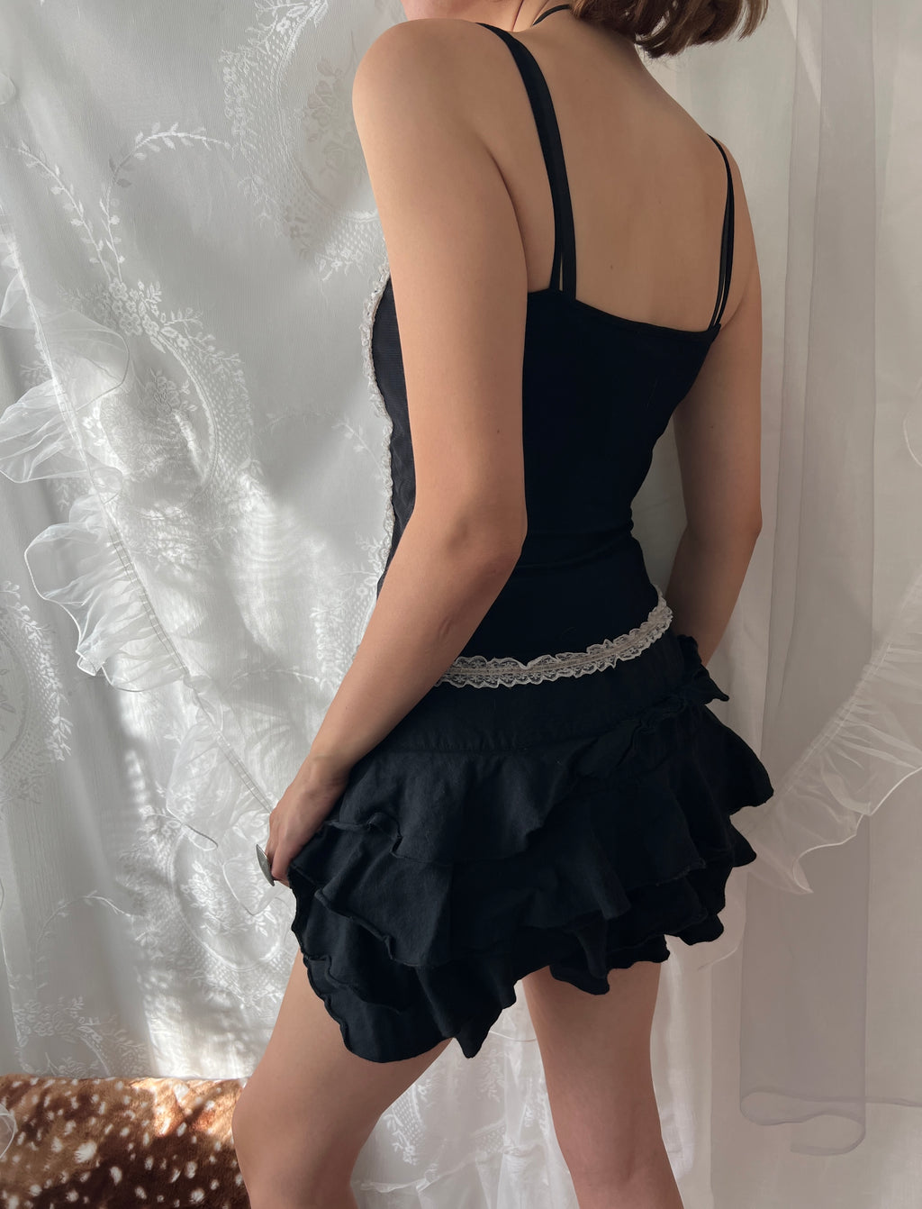 Black lace corset top with white lace trim and adjustable straps
