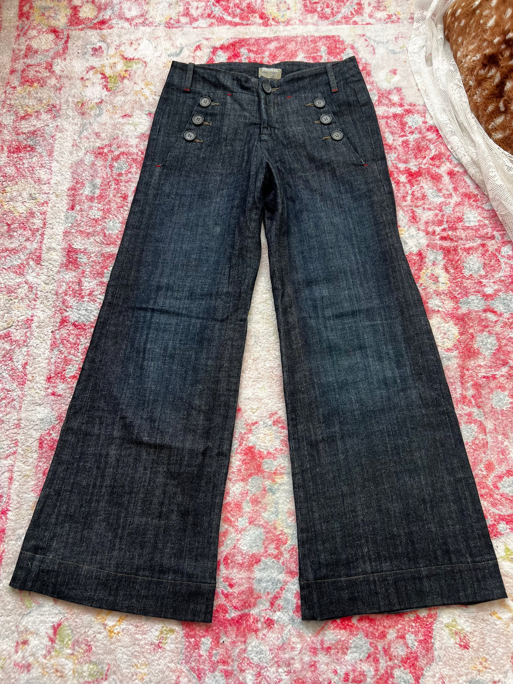 Dark wash denim jeans with button details and wide leg fit