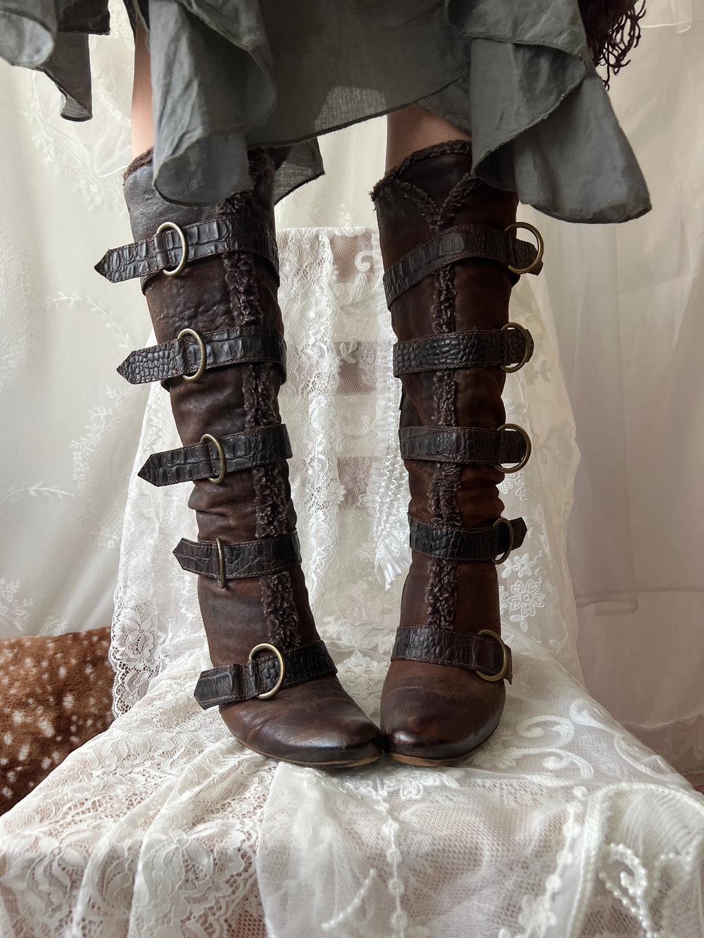 Brown leather knee high boots with buckles and faux fur trim
