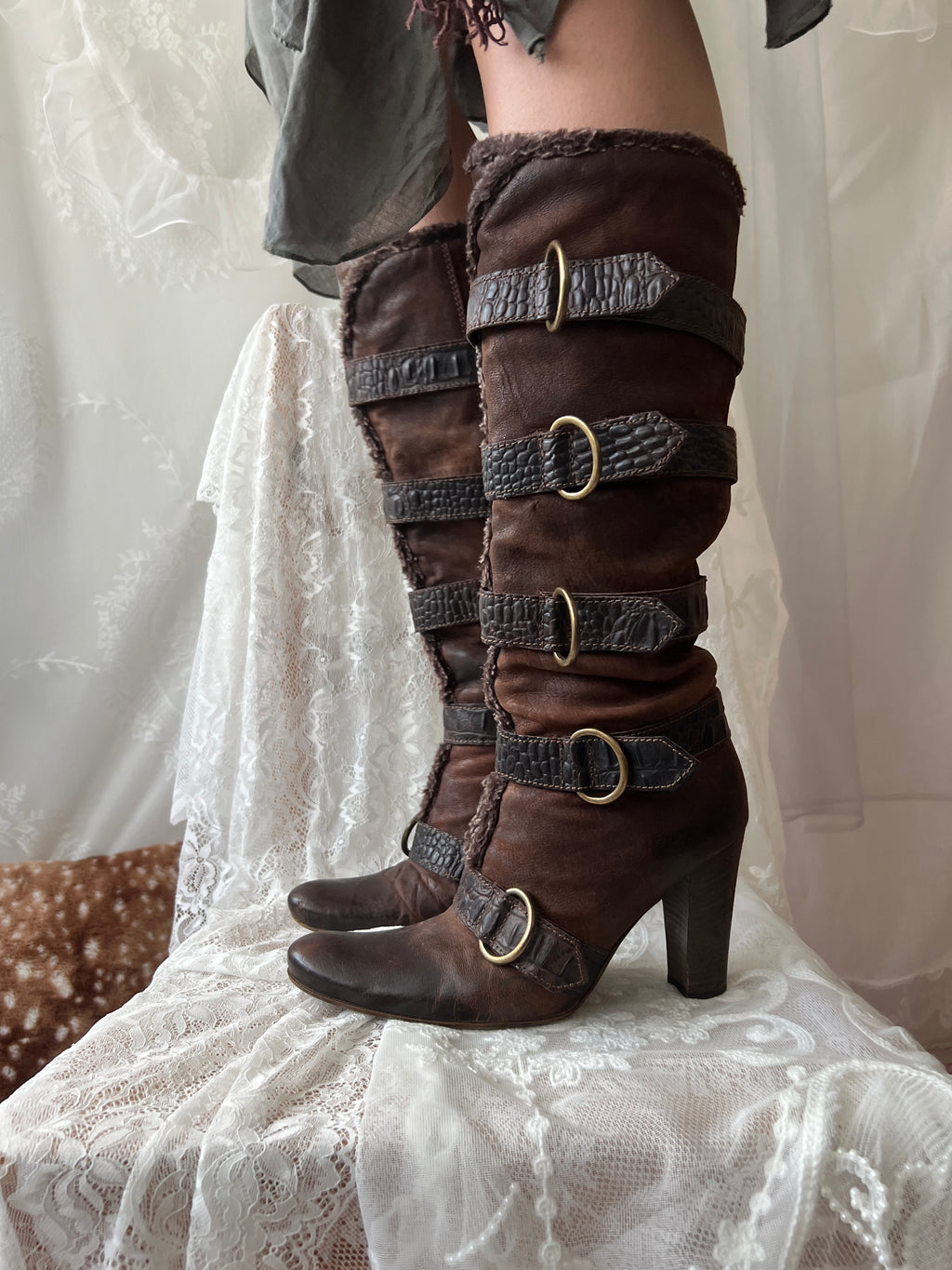Brown leather knee high boots with buckles and faux fur trim