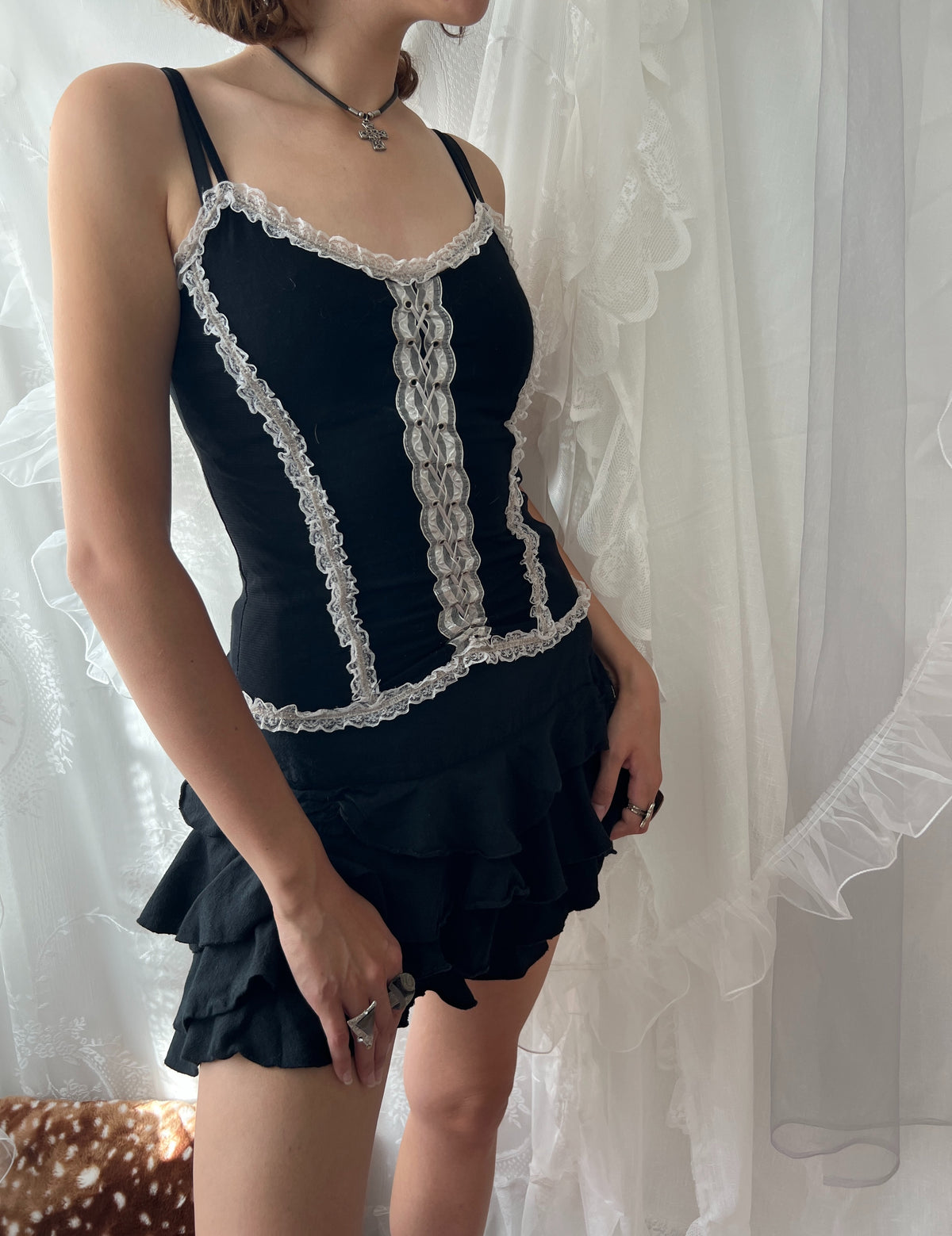 Black lace corset top with white lace trim and adjustable straps
