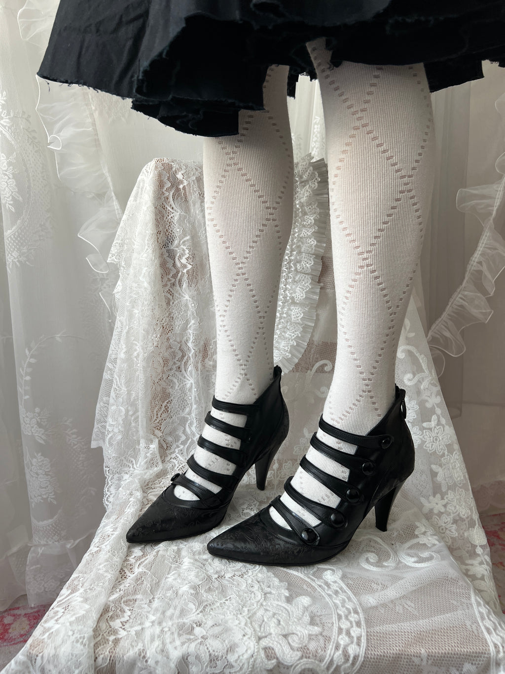 Black leather kitten heels with pointed toe and button details