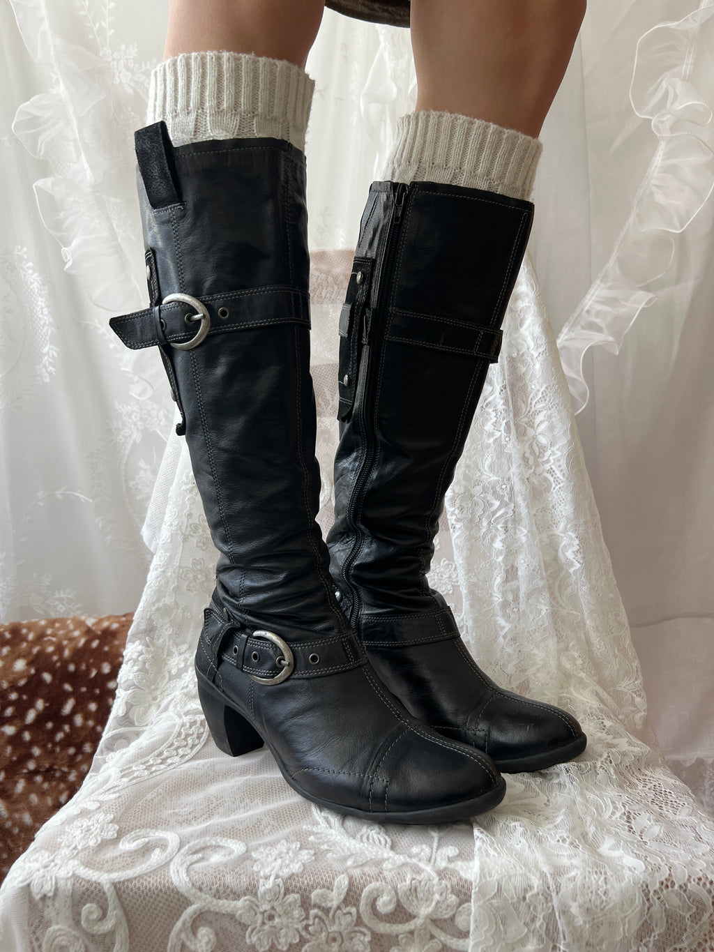 Black knee high boots with silver buckles