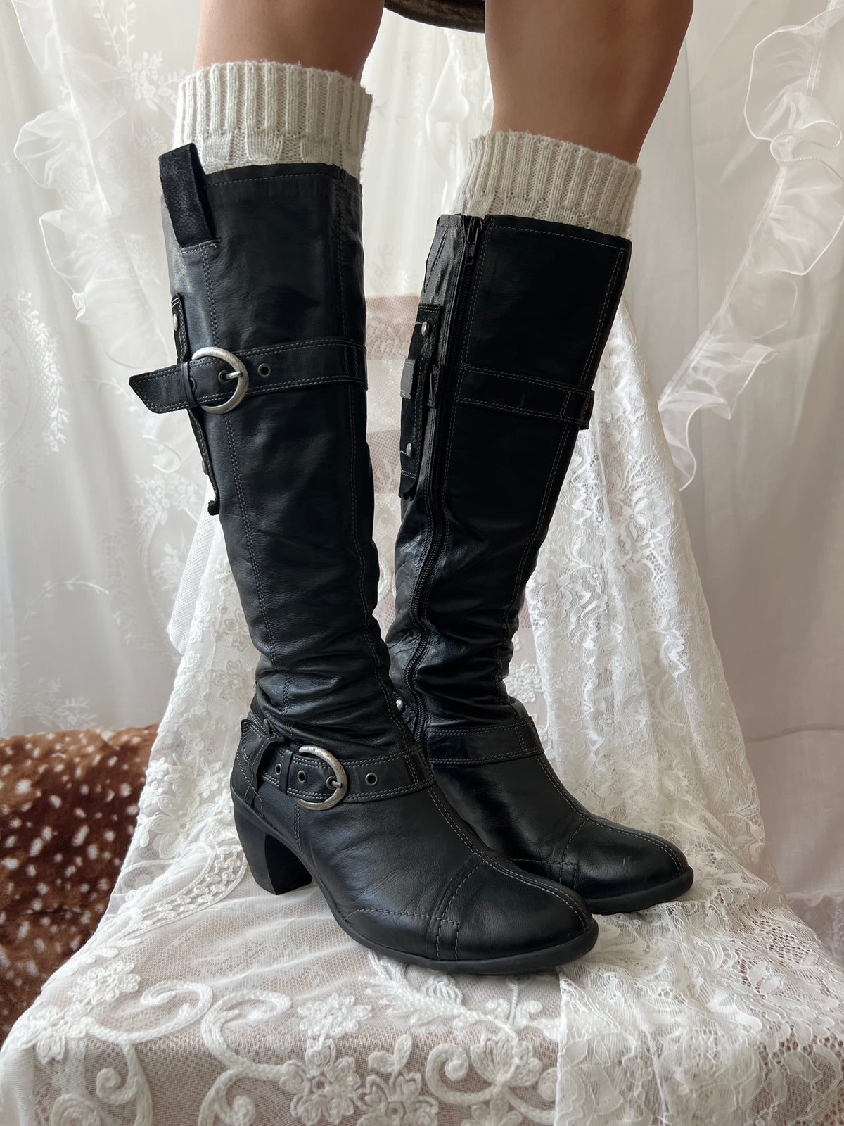 Black knee high boots with silver buckles