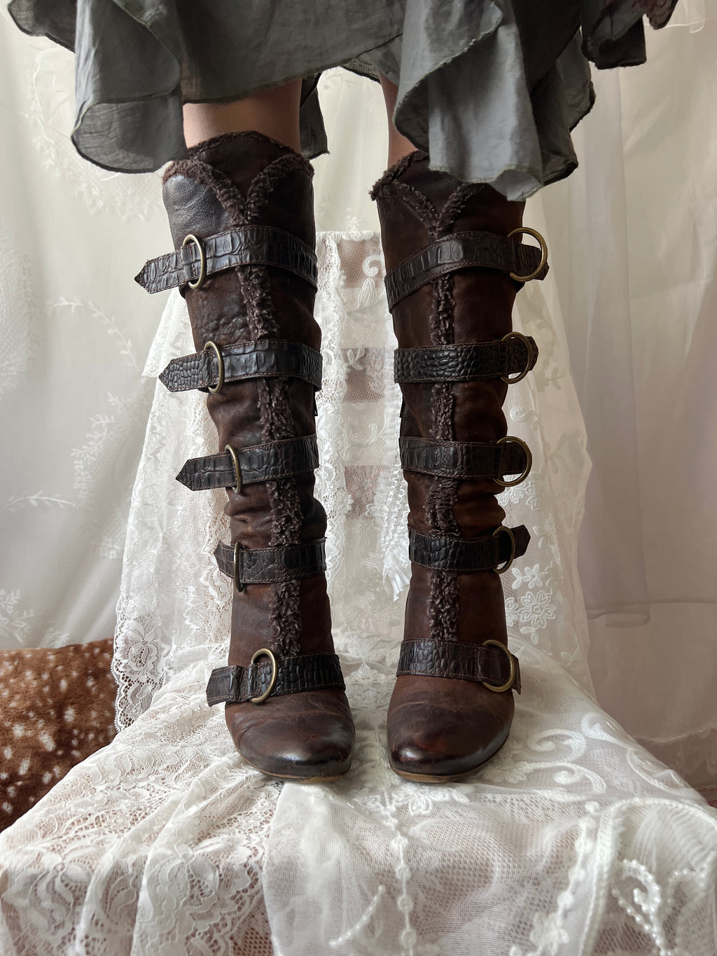 Brown leather knee high boots with buckles and faux fur trim