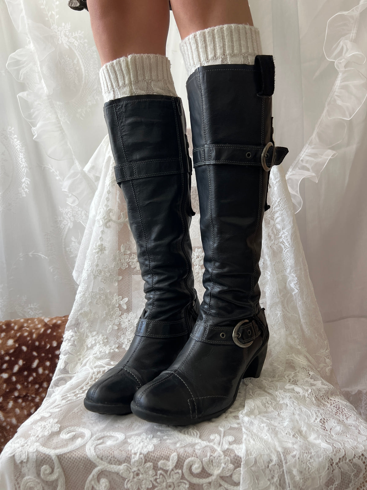 Black knee high boots with silver buckles